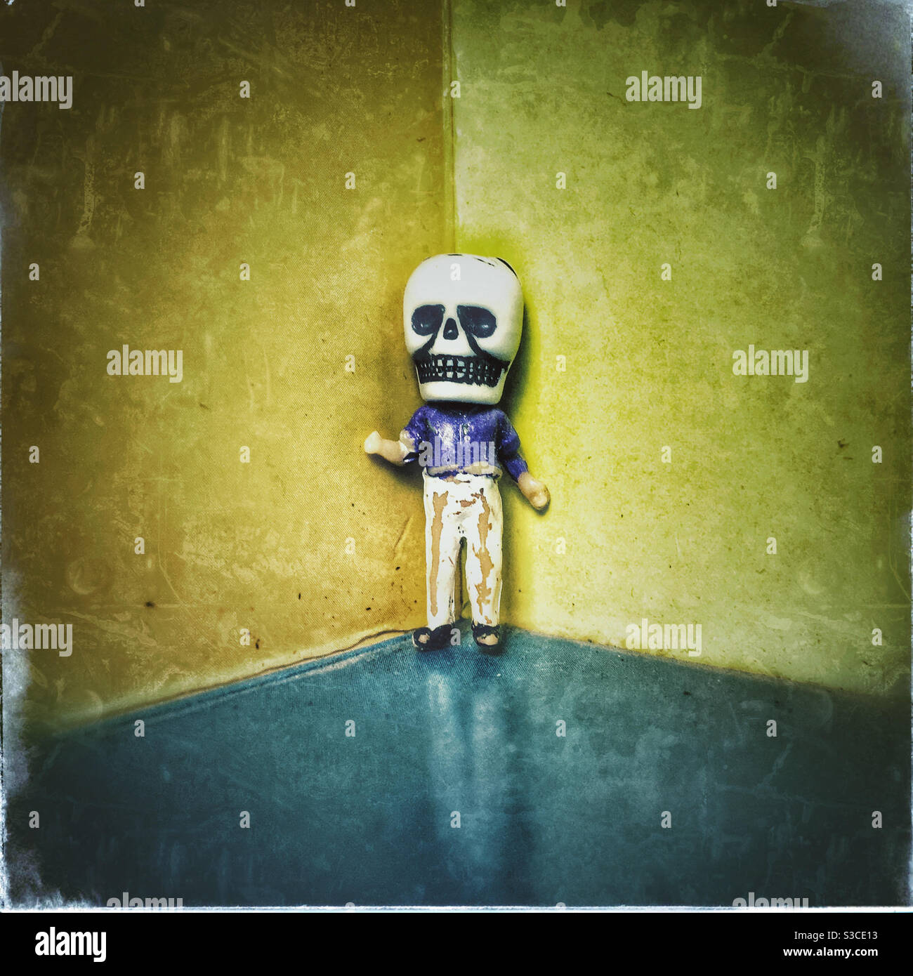 Figur in einer Totenkopf-Maske in der Ecke des Ein Zimmer - Smartphone-aufgenommenes Stockfoto