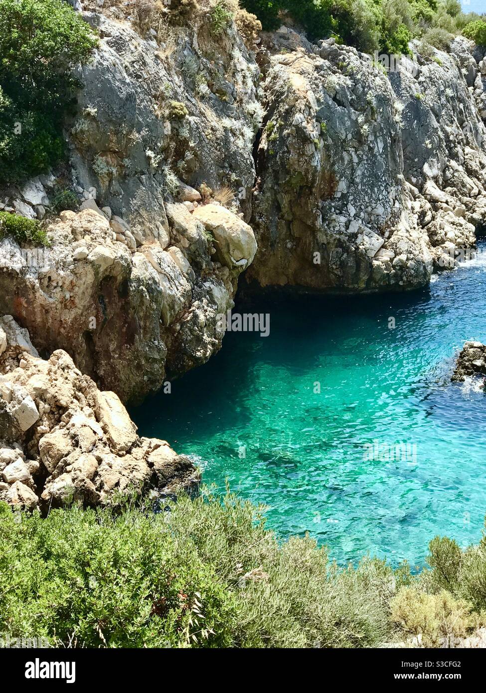 Kristallklares türkisblaues Meer in einer felsigen Bucht entlang Die Südküste der Türkei bei Kas in der hellen Sommersonne Stockfoto