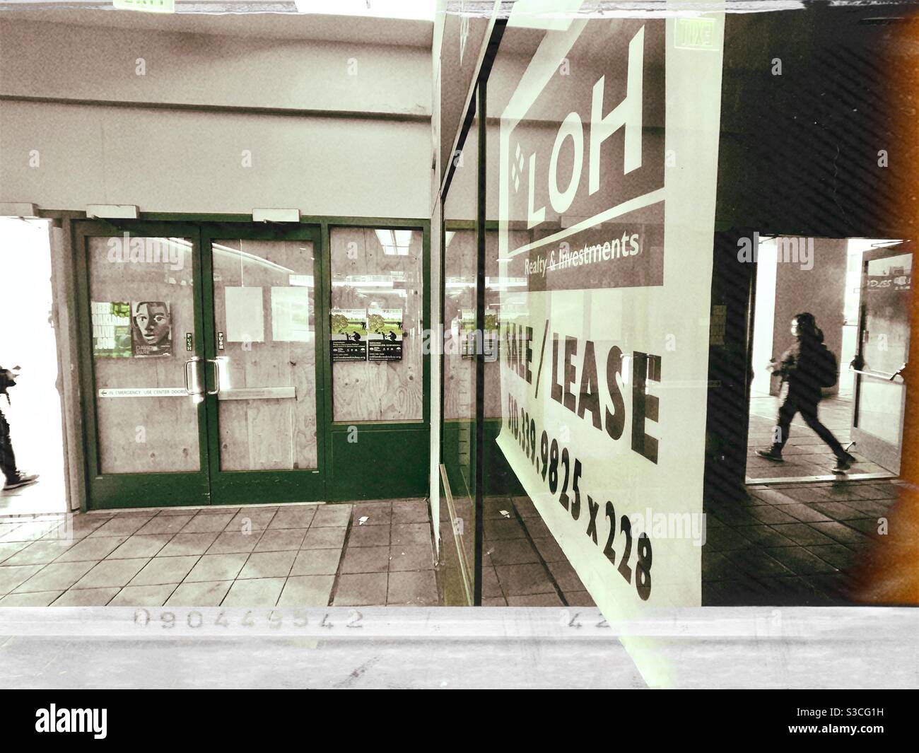 Die Szene aus dem Inneren des Pacific Renaissance Plaza in Oakland Chinatown, Kalifornien, ist die Türen, das Raumplakat und zwei wandelende Menschen zu sehen. Stockfoto