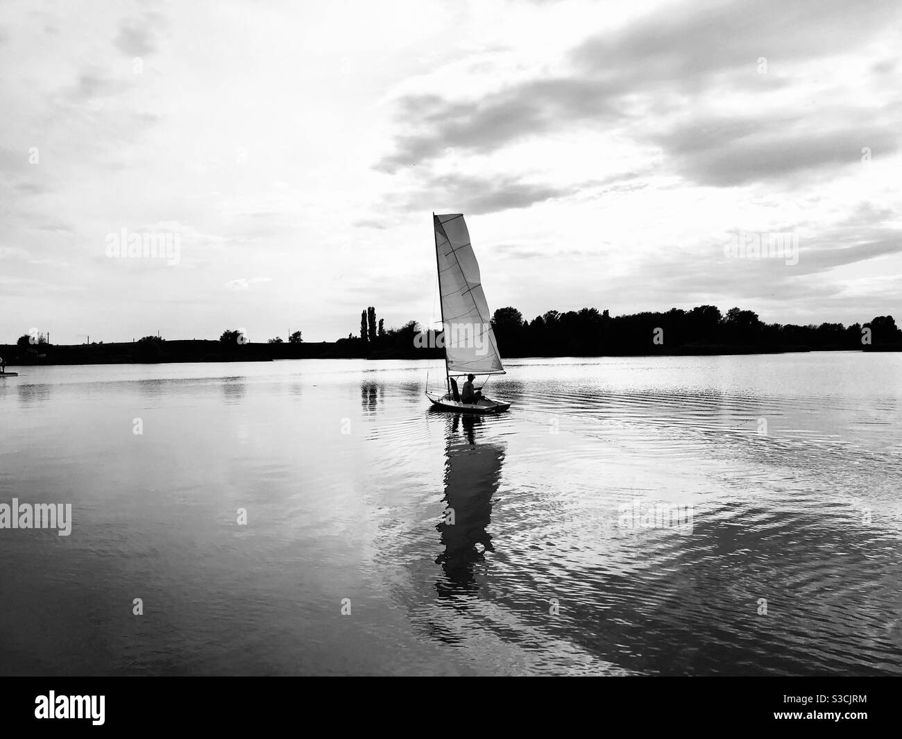Schwarz-Weiß-Foto von Boot auf einem See reflektierend Im Wasser Stockfoto