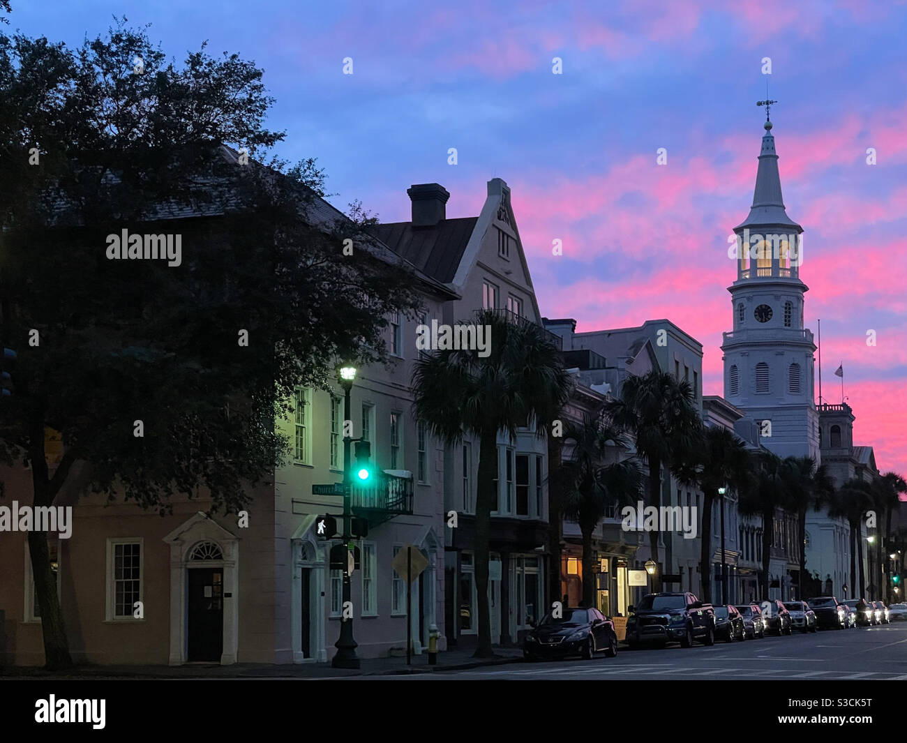 Sonnenuntergang über der Broad Street in Downtown Charleston, South Carolina, USA mit dem Kirchturm der St. Michael Church im Hintergrund. Die Episkopalkirche ist eine der ältesten erhaltenen religiösen Strukturen. Stockfoto