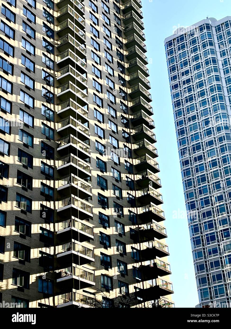 Die Nachmittagssonne wirft Schatten, die interessante geometrische Formen in der Architektur von Wolkenkratzern in Murray Hill, New York City, USA, an der 33rd St. und Third Avenue schaffen Stockfoto