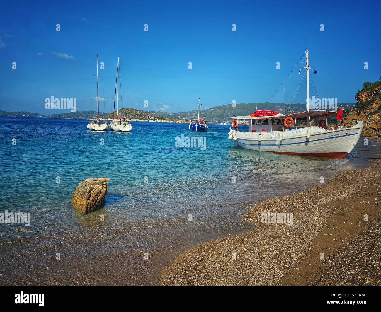 Kleine Boote warten auf Touristen auf Arkos, einer kleinen Insel in der Nähe von Skiathos, Griechenland. - Smartphone-aufgenommenes Stockfoto