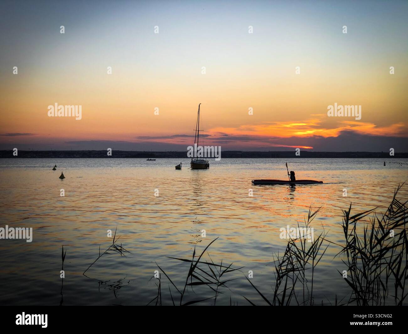 Boote auf dem Wasser bei Sonnenuntergang - Smartphone-aufgenommenes Stockfoto