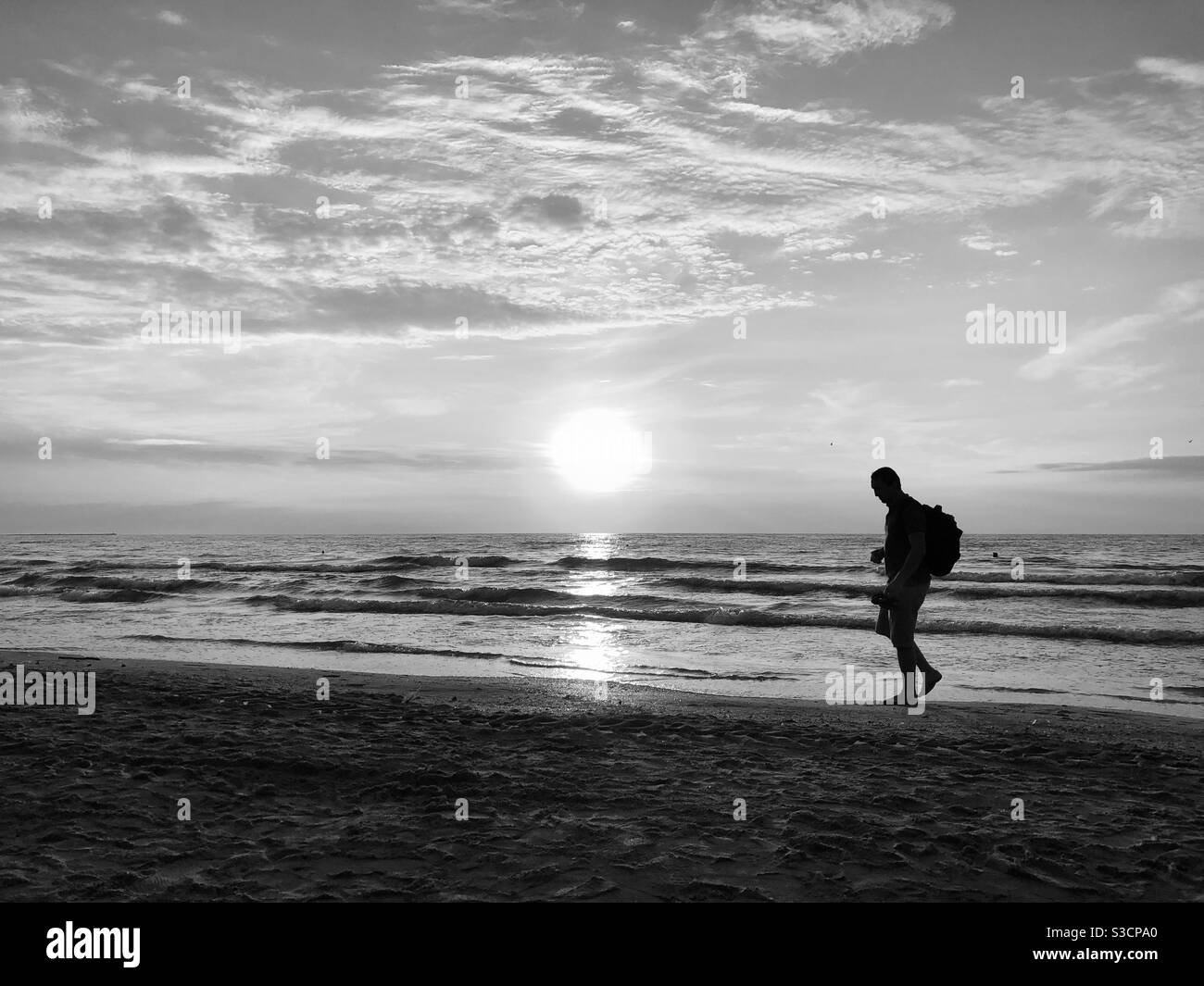 Schwarz-Weiß-Foto von Mann, der allein auf dem Strand - Smartphone-aufgenommenes Stockfoto