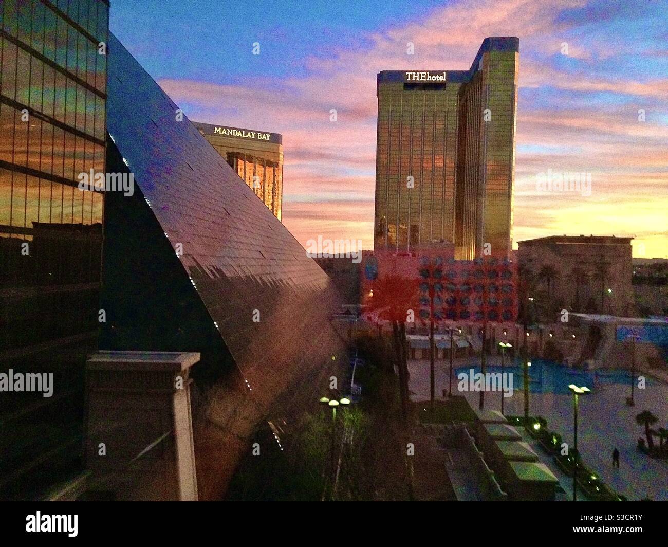 Der strahlende regenbogenfarbene Himmel der amerikanischen Südwestwüste spiegelt sich auf der Glasseite des pyramidenförmigen Luxor Hotels mit dem Hotel im Hintergrund auf dem Las Vegas Strip in Nevada, USA Stockfoto