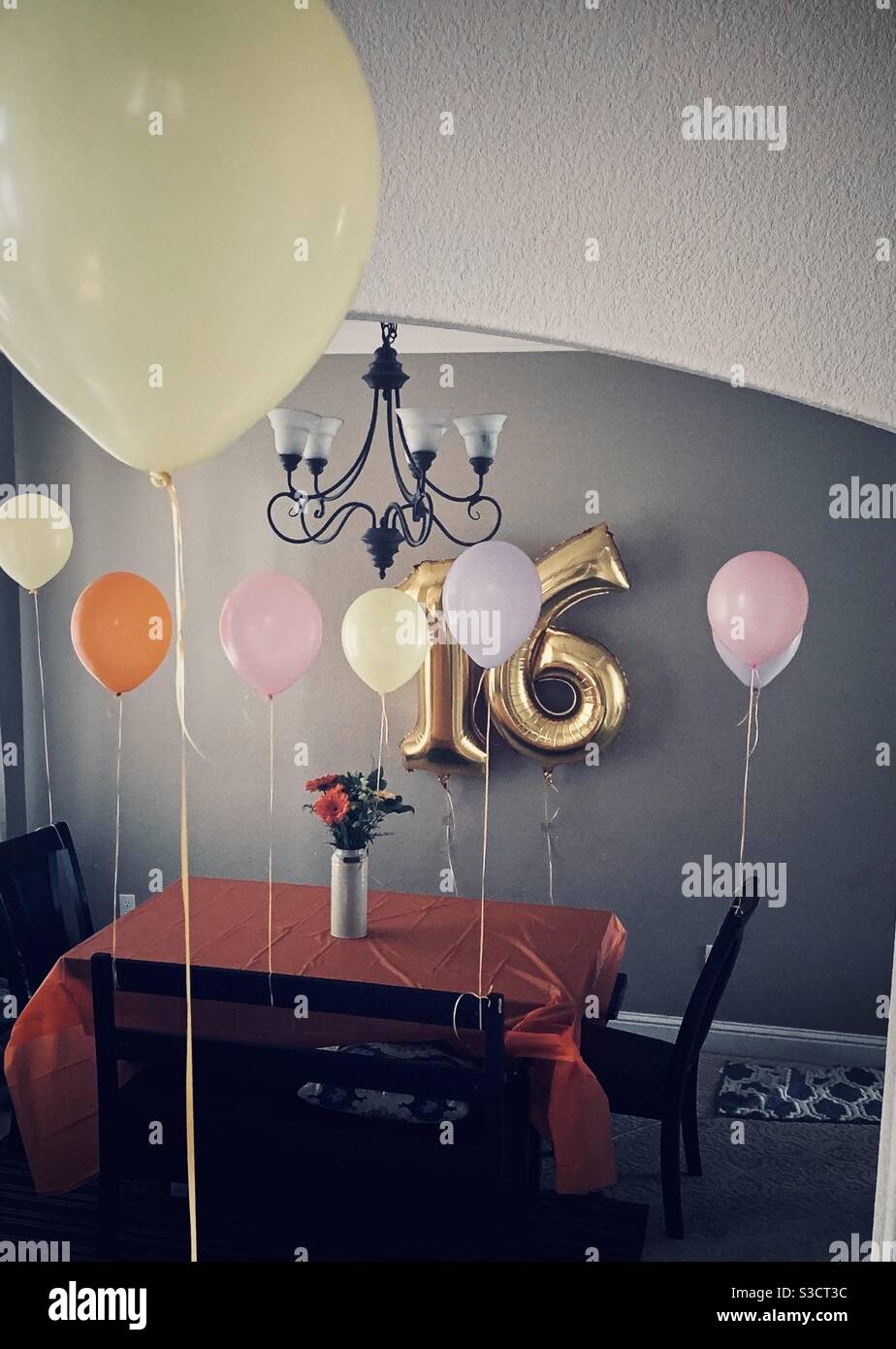 Feiern Sie eine süße sechzehn Geburtstagsfeier mit Ballons und ein Schön dekorierter Esstisch - goldene Ballons und Esstisch Dekoriert für eine Geburtstagsfeier Stockfoto