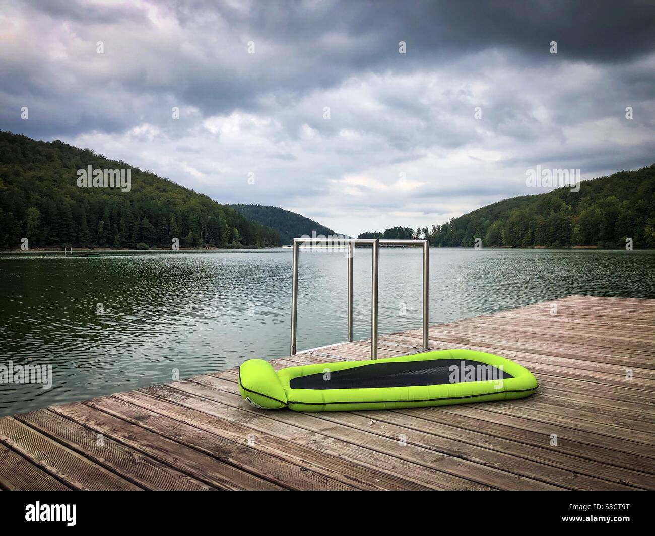 Aufblasbare Luftmatratze auf einem Holzponton in der Nähe des Sees Stockfoto