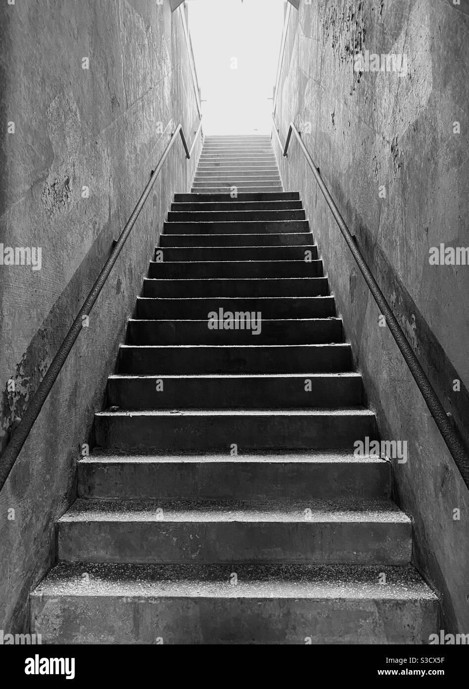 Die Treppe hinauf ins Licht schauen - Smartphone-aufgenommenes Stockfoto