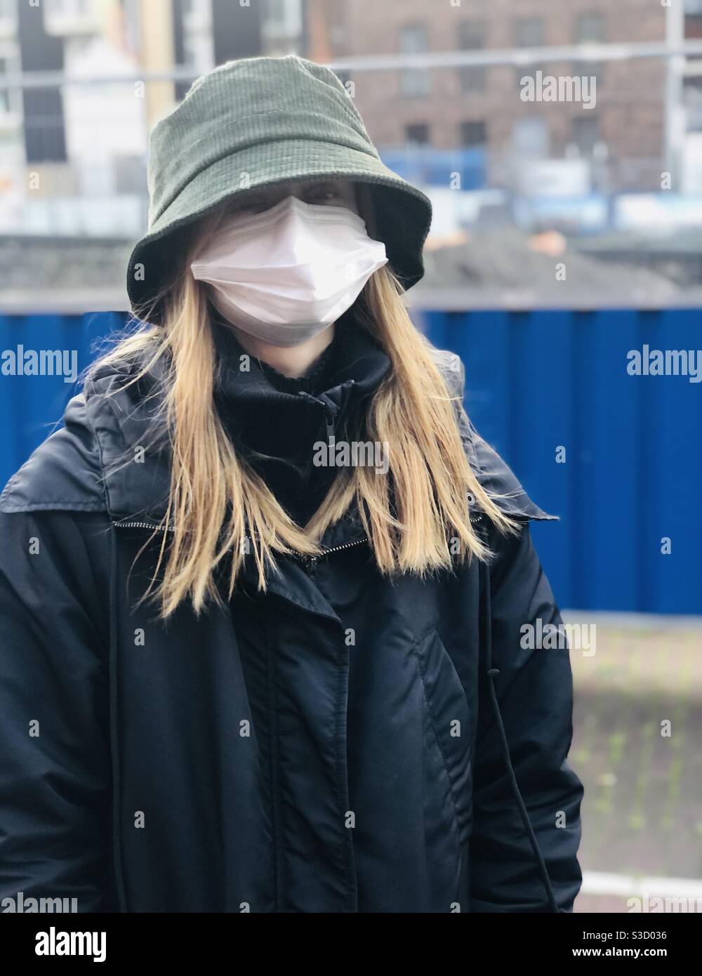 #corona#covid#Portrait#Facemask#Regenmantel #junge Frau#amsterdam#covid#Virus#Krise #weiße Gesichtsmaske#Portrait#Stockfotografie#iphoneography - Smartphone-aufgenommenes Stockfoto