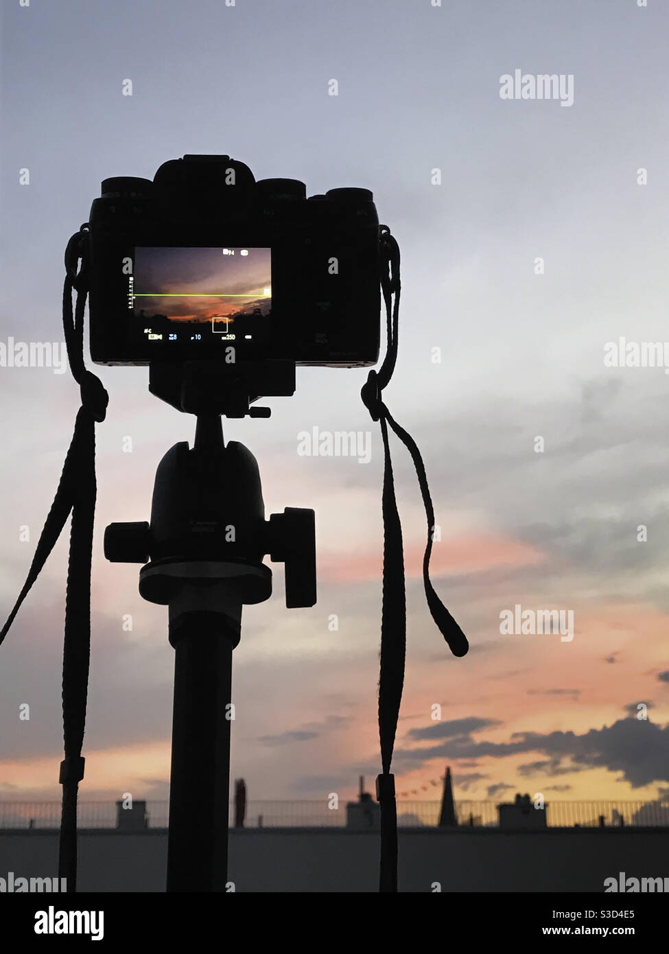Kamera auf Stativ und farbenfroher Sonnenuntergang Stockfoto