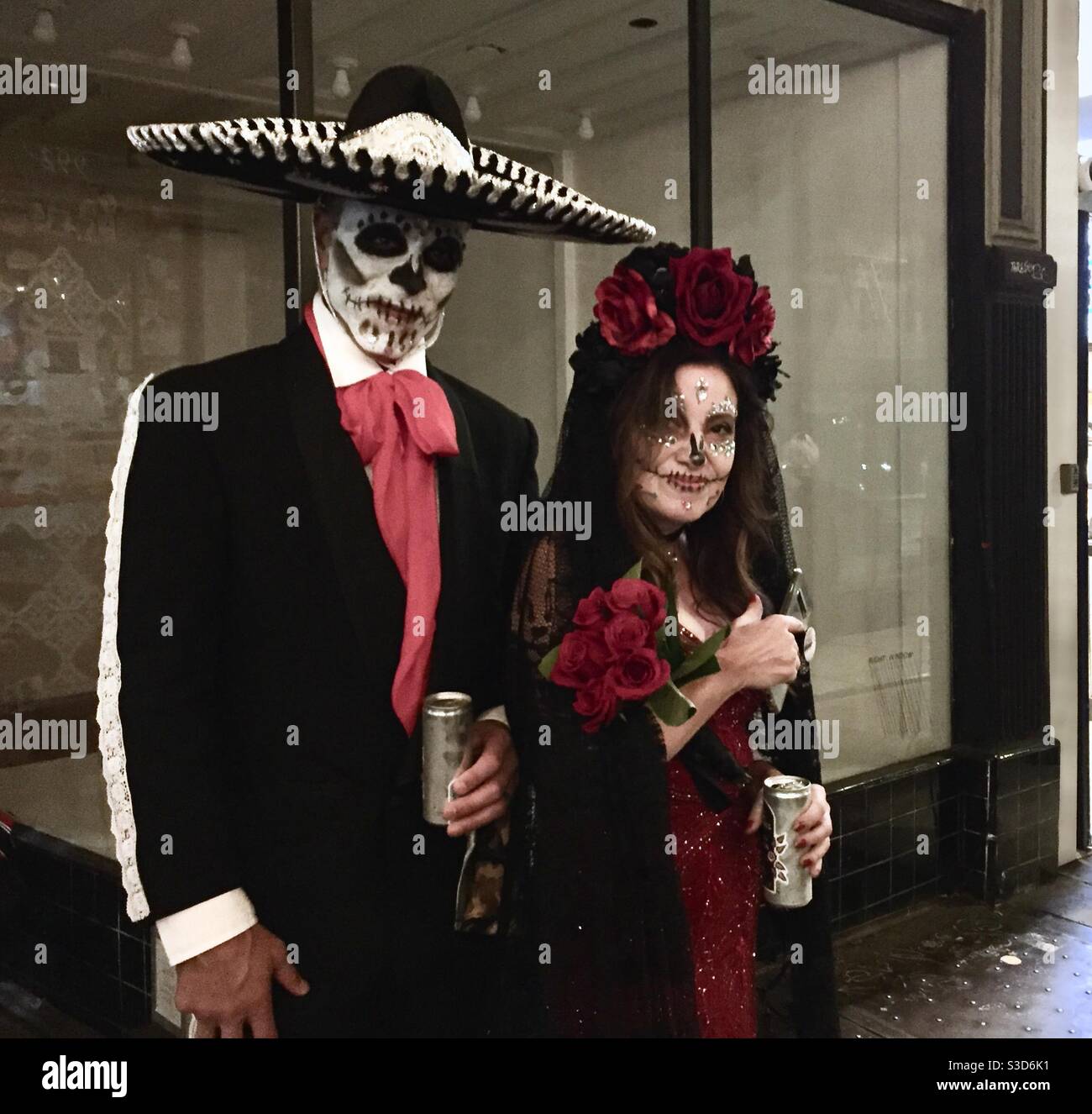 Ein Paar in Day of the Dead Kostümen an Halloween auf der Mission Street in San Francisco, Kalifornien. - Smartphone-aufgenommenes Stockfoto