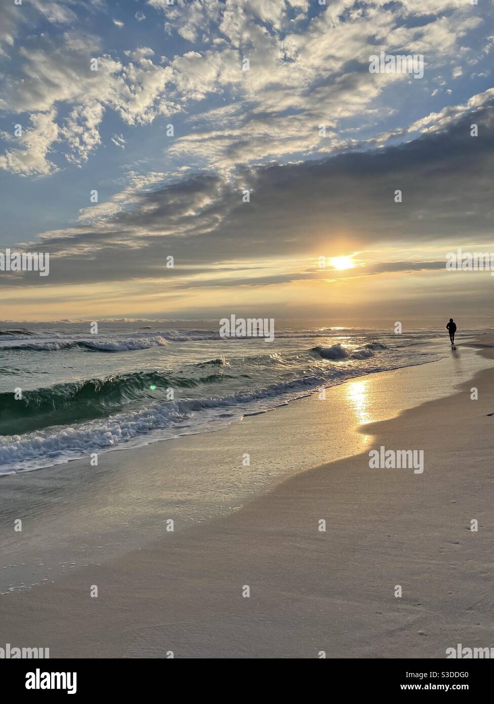 Goldener Sonnenuntergang über dem Golf von Mexiko Florida mit einem Silhouette Person zu Fuß die Küste Stockfoto