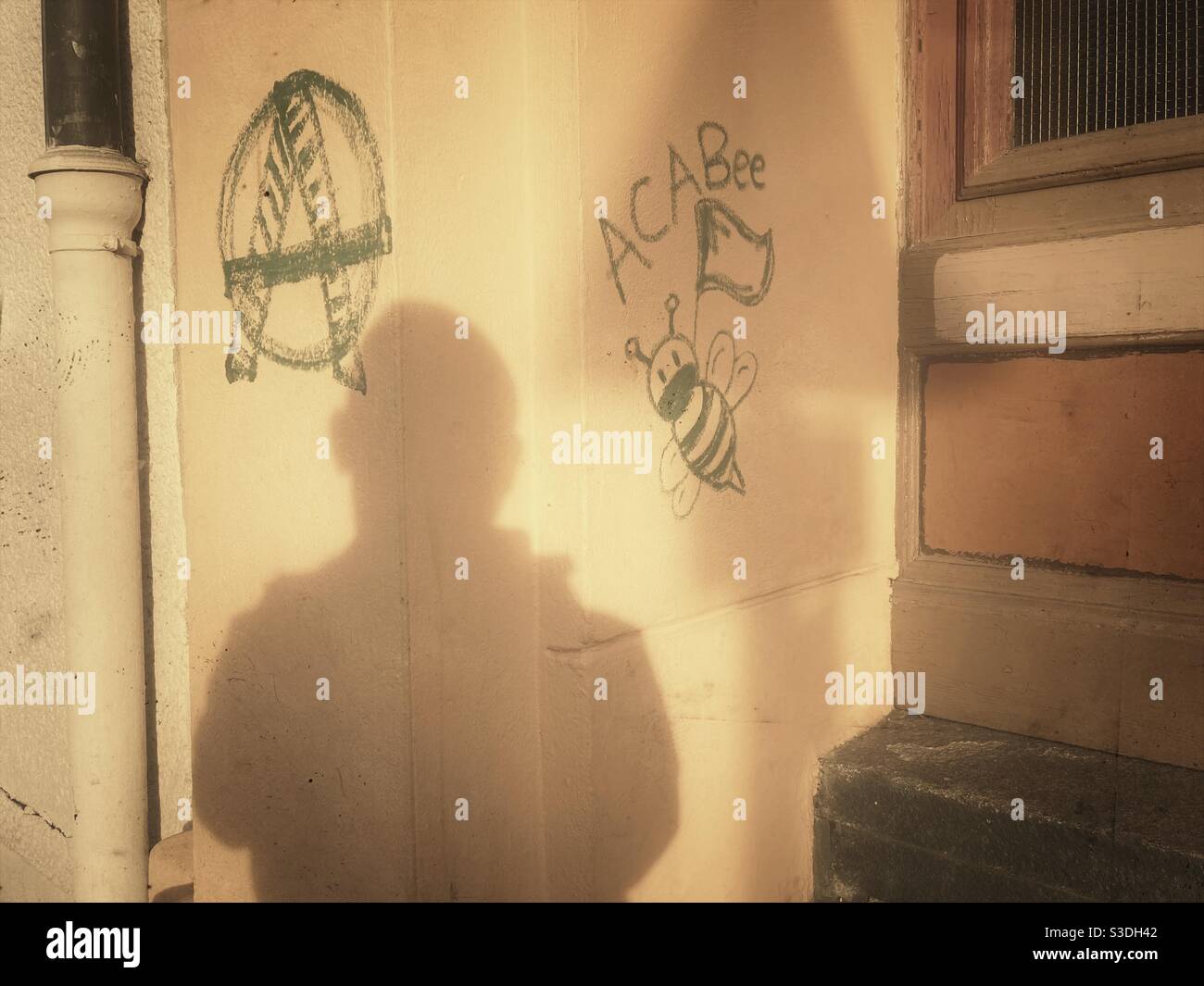 Acabee und Anarchie Graffiti und ein Schatten eines Mannes an einer Mauer in Kreuzberg, Berlin, Deutschland Stockfoto