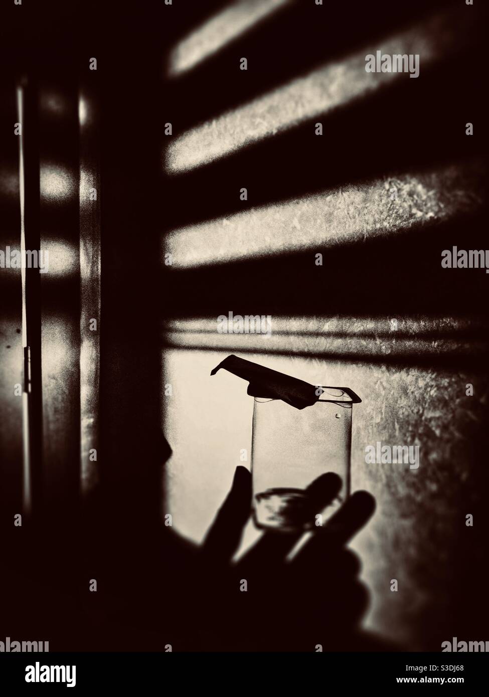 Kontrastreiches Bild einer Hand, die eine Tasse in sich hält Hand - Smartphone-aufgenommenes Stockfoto