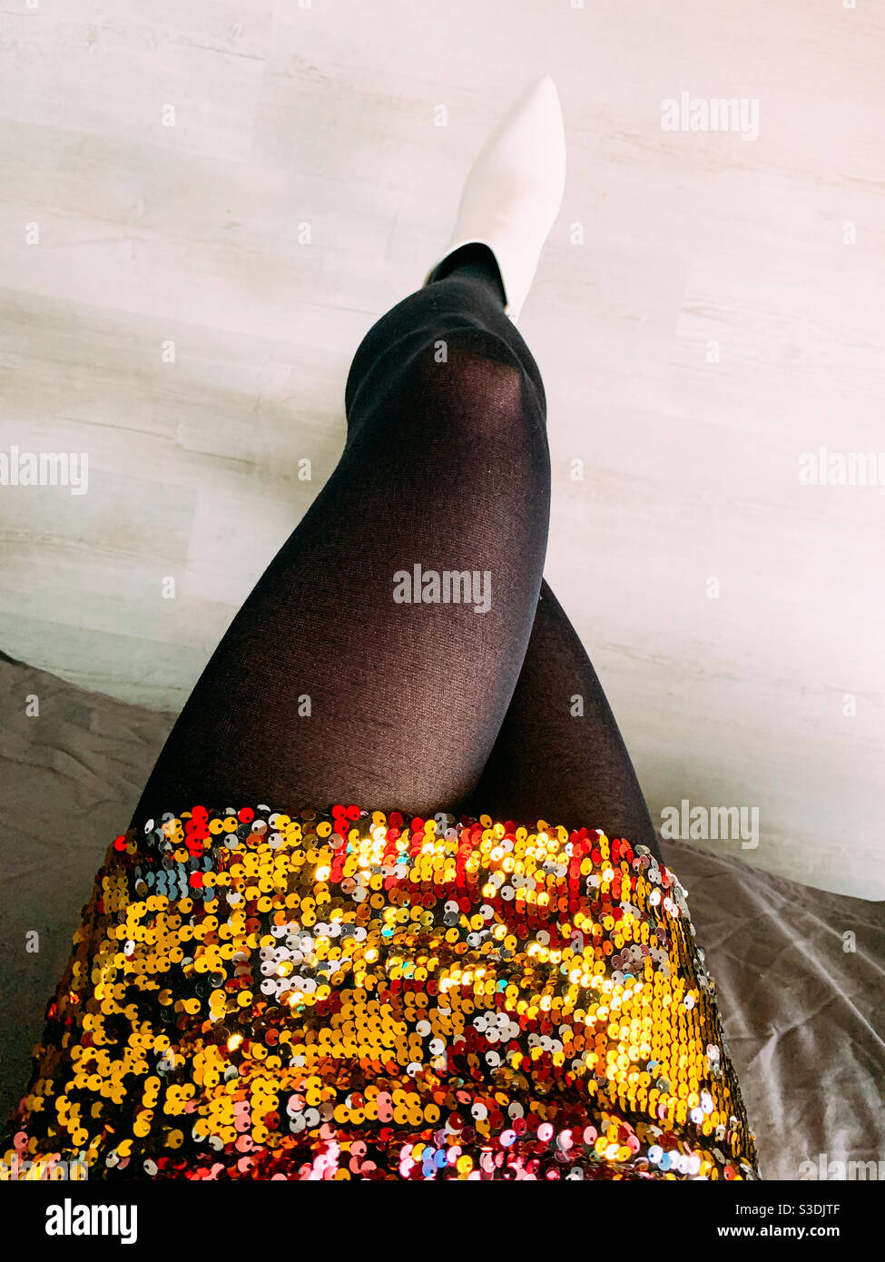 Frau trägt ein Paillettenkleid saß gekreuzt Beinen Stockfoto