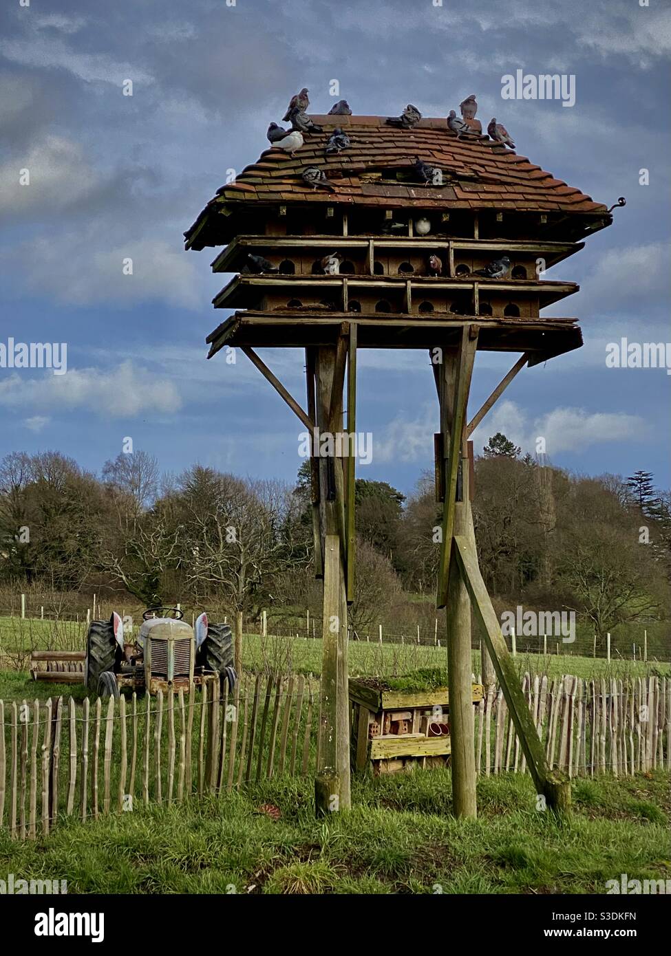 Dovecote auf einem Holzbau in der Nähe eines Feldes und Traktor Mit Tauben Tauben und Holzzaun in der East Sussex Kent Grenze Landschaft Stockfoto