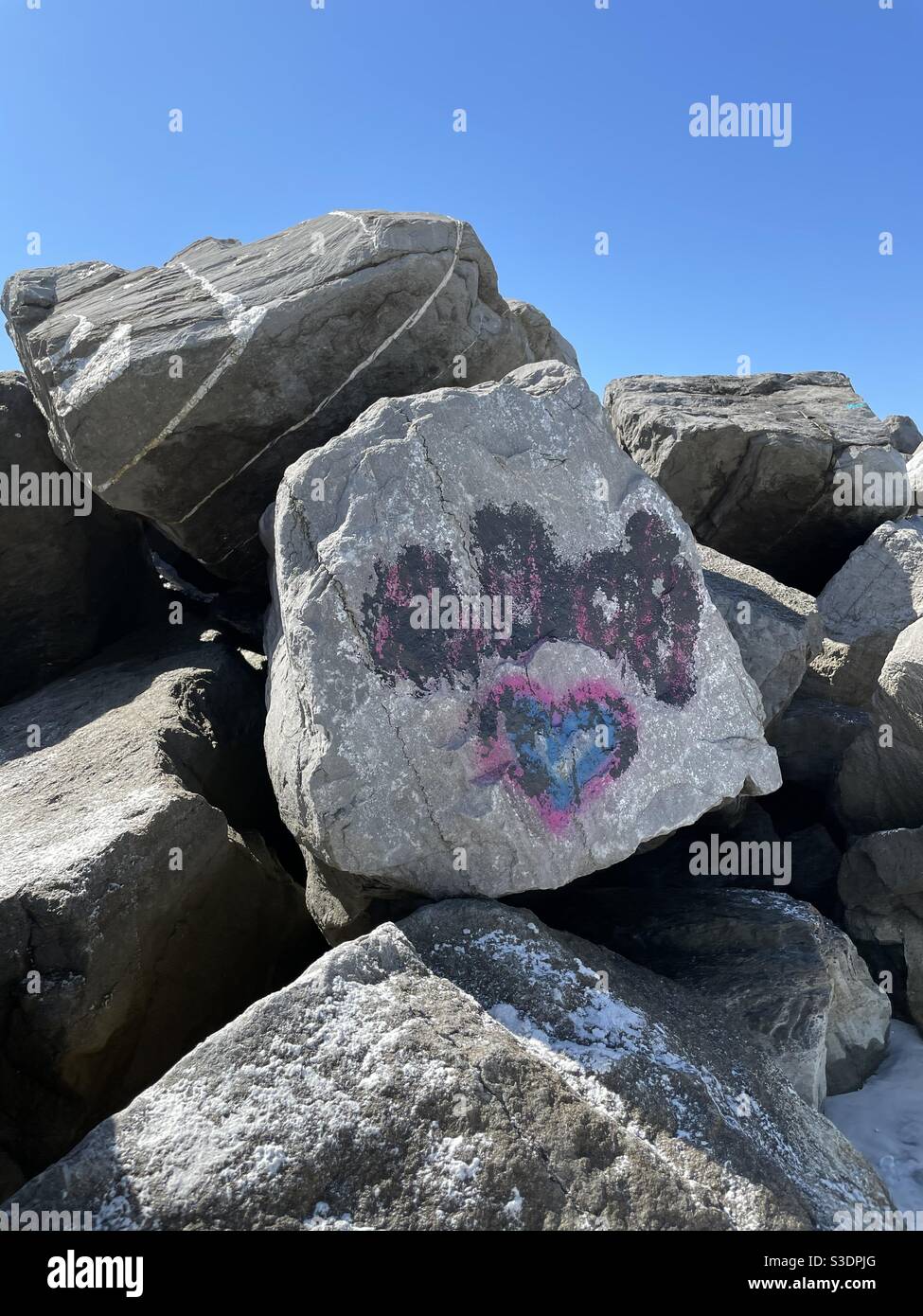 Rosa und blaues Herz Graffiti auf Steg Strand Felsen Stockfoto