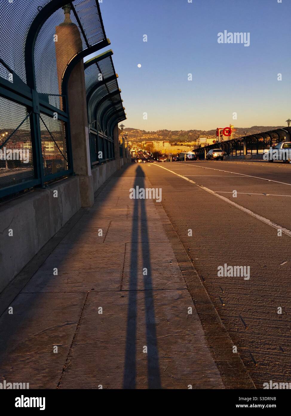 Vollmond mit langem Schatten auf der Shellmound Bridge in Emeryville, Kalifornien in der Abenddämmerung. Stockfoto