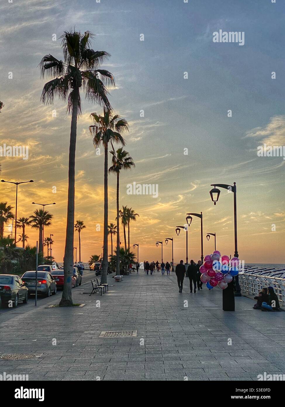 Reizende Beirut - Lebanon Promenade bei Sonnenuntergang mit Menschen zu Fuß Am Meer und eine Dame, die farbige Ballons verkauft - Smartphone-aufgenommenes Stockfoto