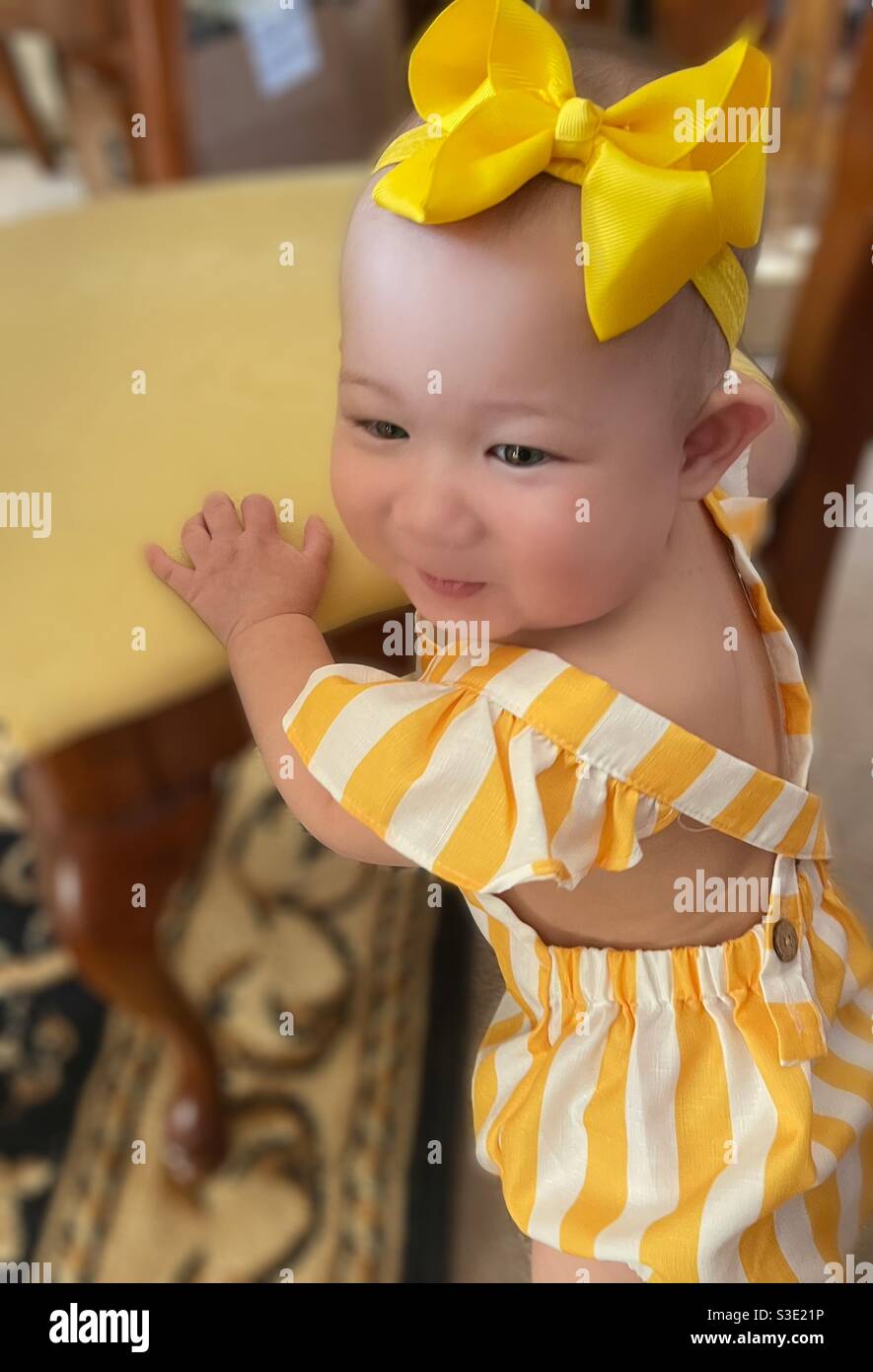 Nettes Baby Mädchen in gelben Streifen Stockfoto