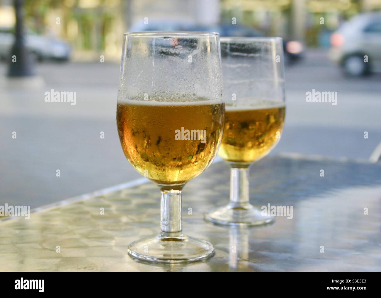 2 Gläser Bier auf einem Metalltisch im Freien Stockfoto