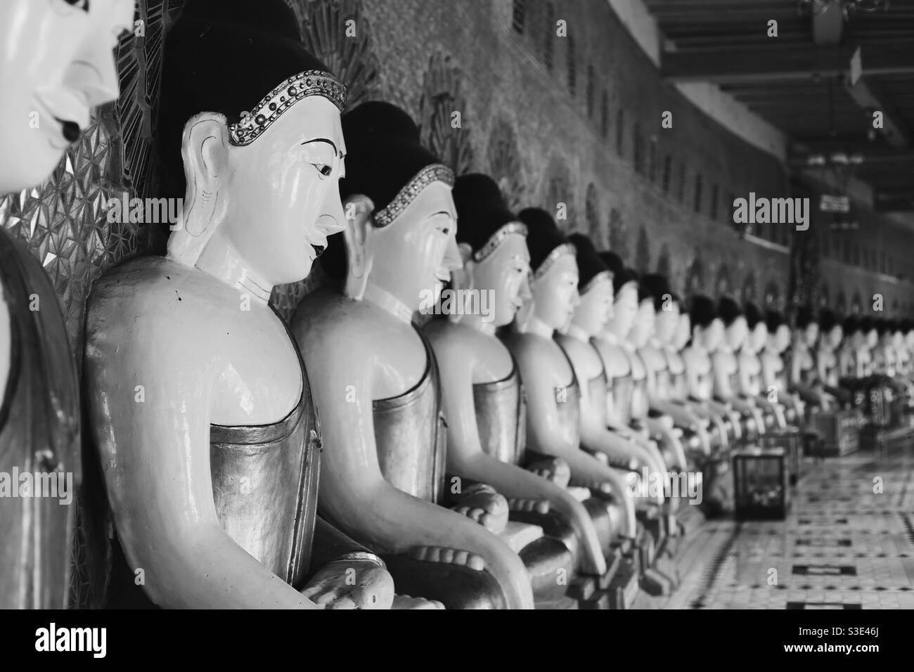Eine Reihe von Buddha-Statuen in Sagaing, Myanmar in Schwarz und Weiß Stockfoto