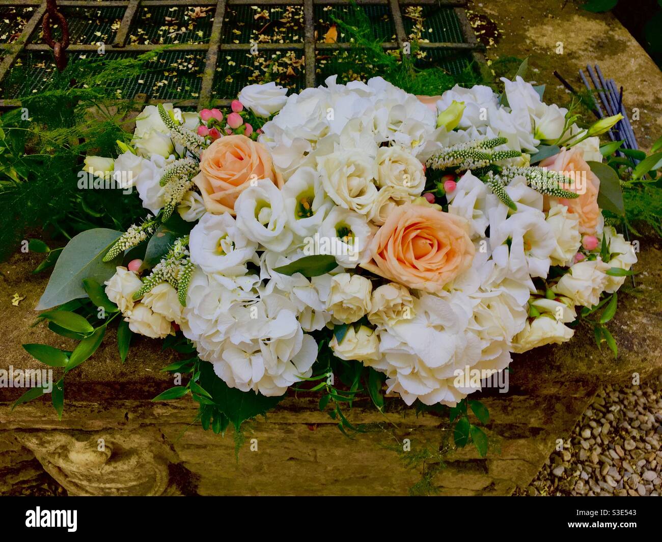 Pfirsich, rosa und weiß Brautblumenstrauß auf Steinwand Stockfoto