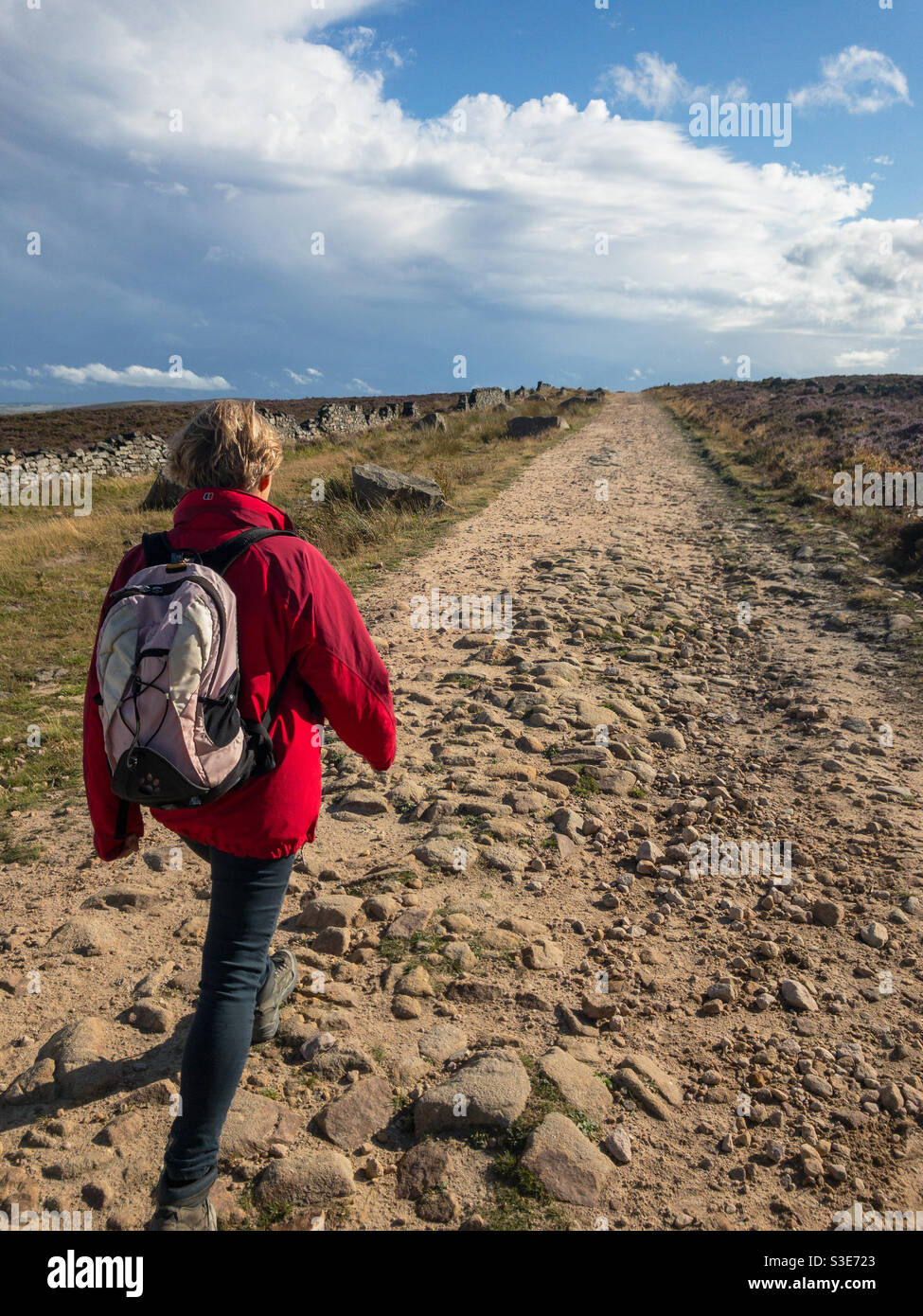 Frau beim Wandern entlang der Houndkirk Road, Peak District, Großbritannien Stockfoto