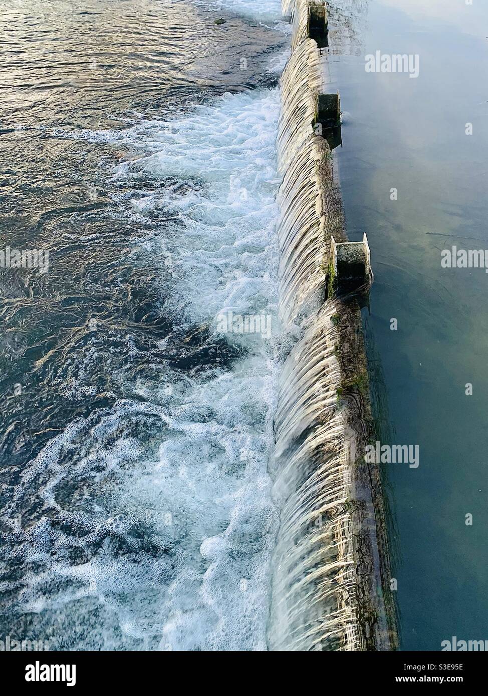 Wasser sprudelt über einem Weir Stockfoto