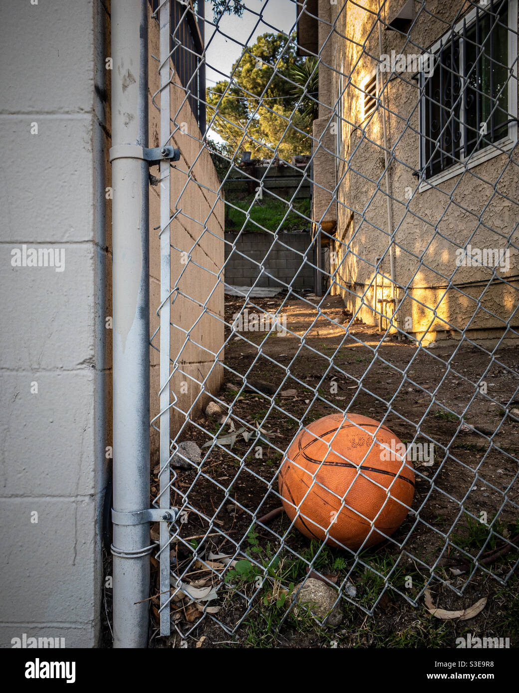 Basketball im Hinterhof als Metapher für verlorene Kindheit Stockfoto