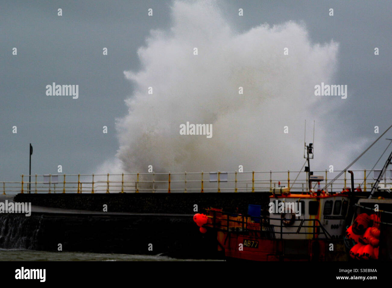 Aberystwyth, West Wales, Großbritannien. Sonntag, 28. März 2021. Wetter: Stürmische Meere schlagen heute Morgen die Mauern von Aberystwyth. Bildnachweis ©️ Rose Voon /Alamy Live News. Stockfoto