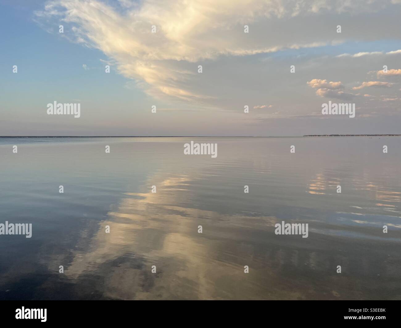 Flauschige weiße Wolken, die sich auf das ruhige Lorbeerwasser spiegeln Stockfoto