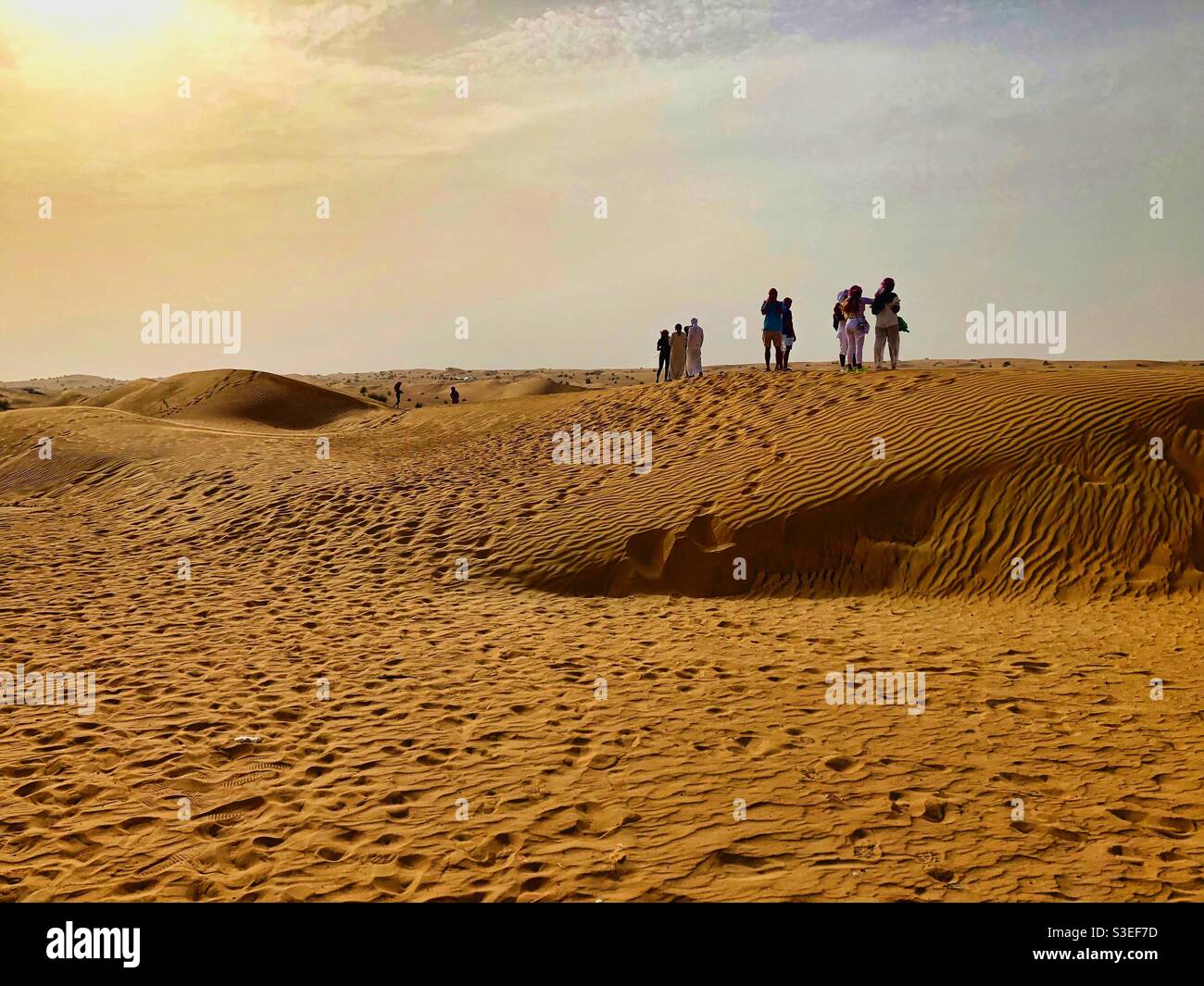 Wüstenlandschaft mit touristischen Silhouetten in der Nähe von Dubai, VAE. - Smartphone-aufgenommenes Stockfoto