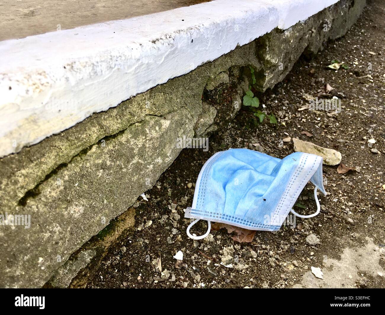 Weggeworfener PPE-Gesichtsmaskenstreuer - Smartphone-aufgenommenes Stockfoto
