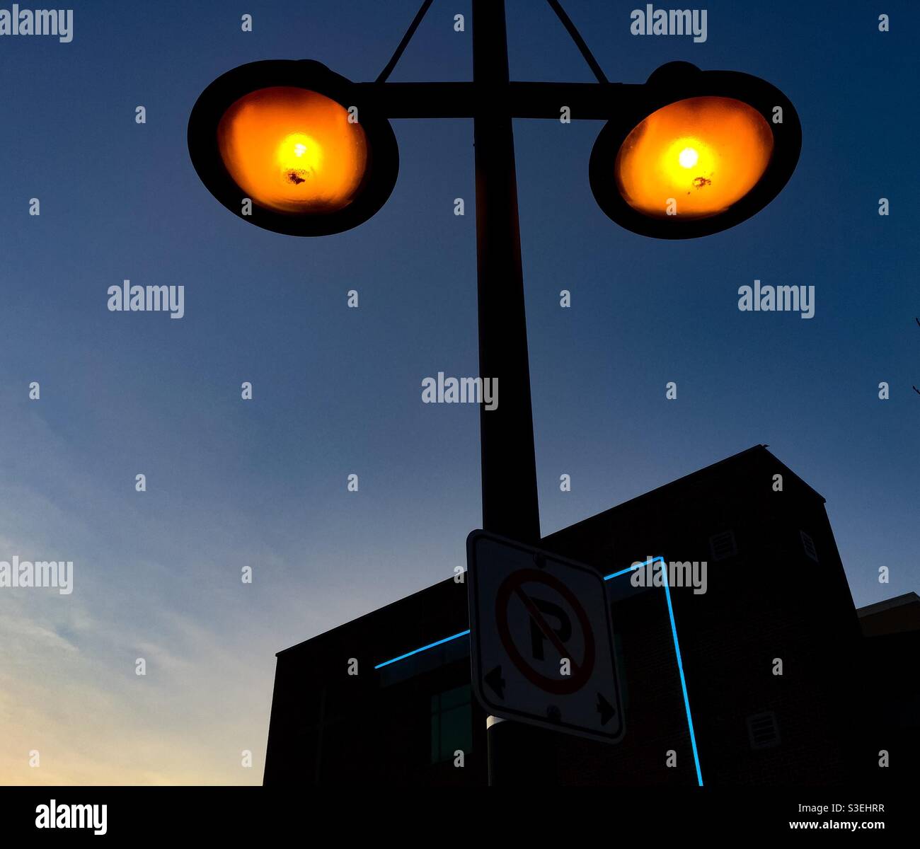 Lichtgeometrie mit vertikalen, horizontalen und runden Elementen, ein warmes Leuchten am blauen Himmel, Ontario, Kanada. Konzepte: Symmetrie, Ordnung, Formen, Balance. - Smartphone-aufgenommenes Stockfoto