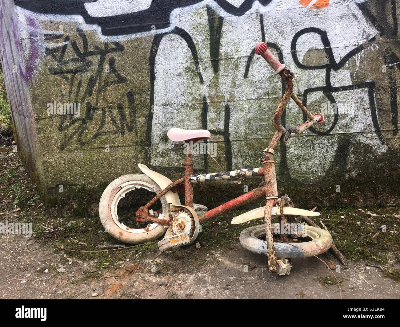 Lange verlassene rostige Fahrrad mit Graffiti Stockfoto