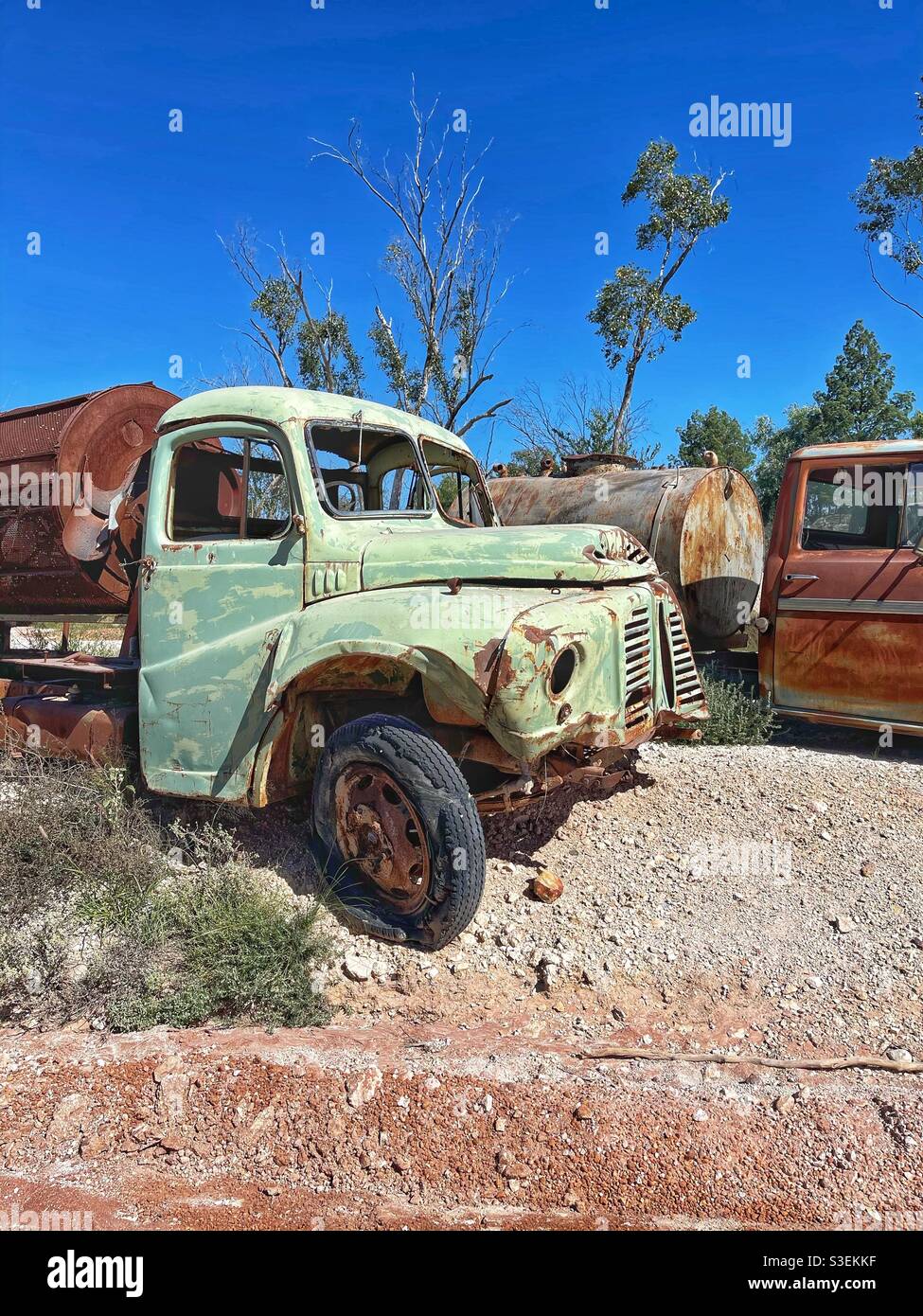 Alte Tankwagen gegen klaren blauen Himmel und Bäume auf den Opalfeldern in der Nähe von Lightning Ridge, New South Wales, Australien - Smartphone-aufgenommenes Stockfoto