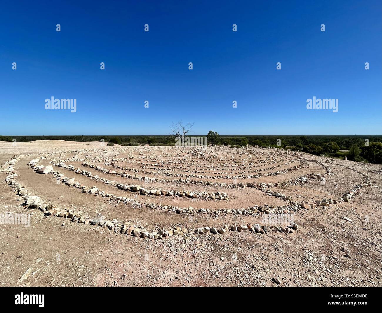 Szenischer Blick auf ein handverlegtes Steinlabyrinth vor klarem blauen Himmel beim First Shaft Lookout in Lightning Ridge, New South Wales, Australien Stockfoto