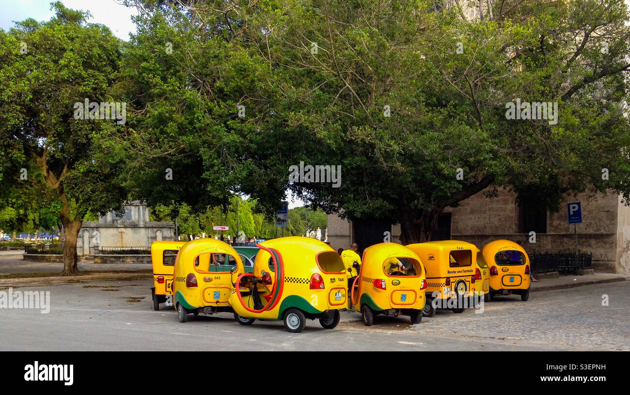 Eine Gruppe von malerischen gelben Coco-Taxis parkte auf Kunden in Havanna, Kuba Stockfoto