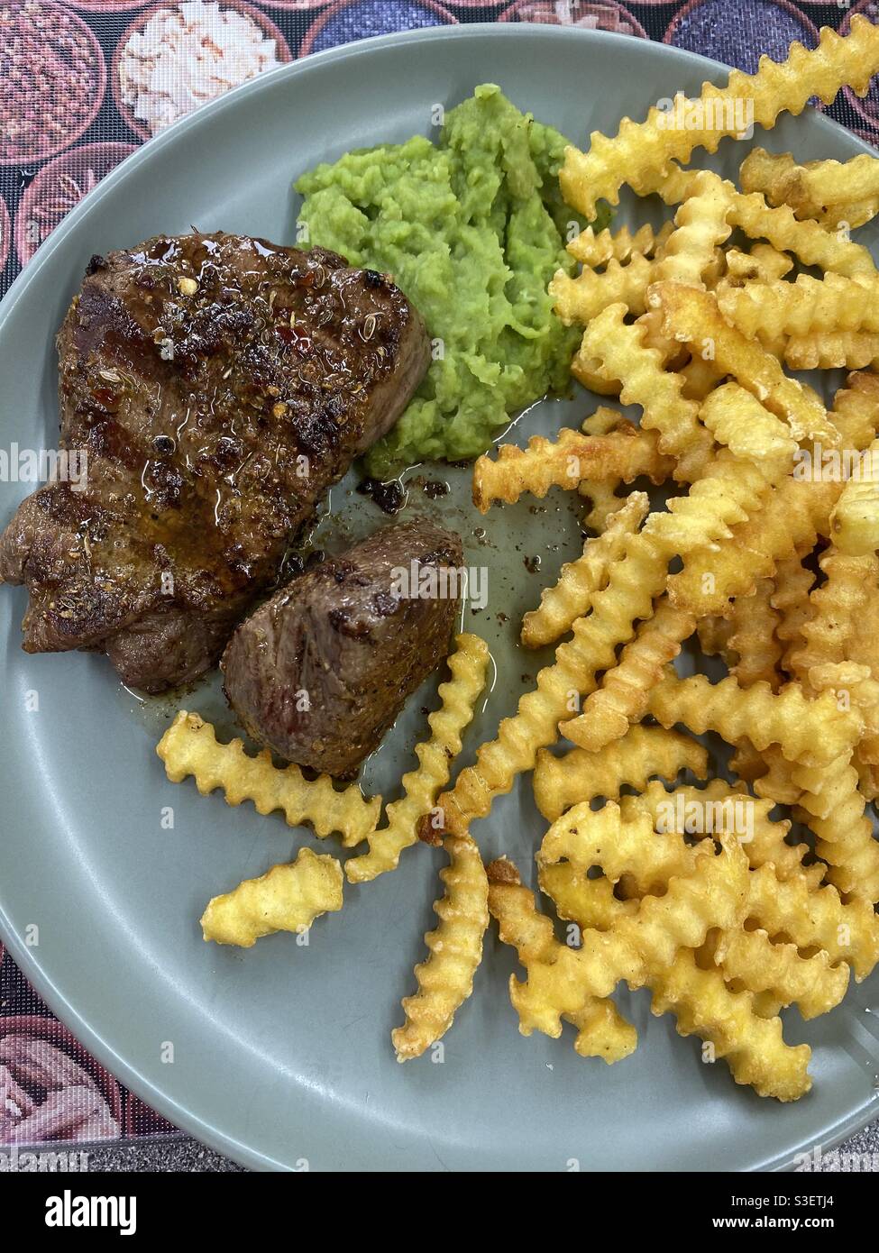 Filetsteak, matschige Erbsen, Extra-Crinkle-Chips und Fleischsäfte Stockfoto