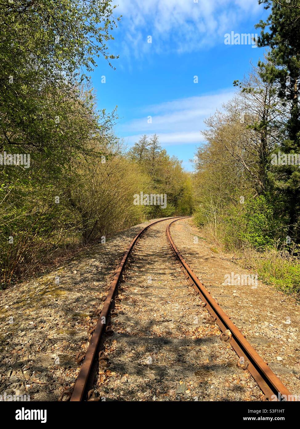 Einspurige Eisenbahnlinie durch die Landschaft - Smartphone-aufgenommenes Stockfoto