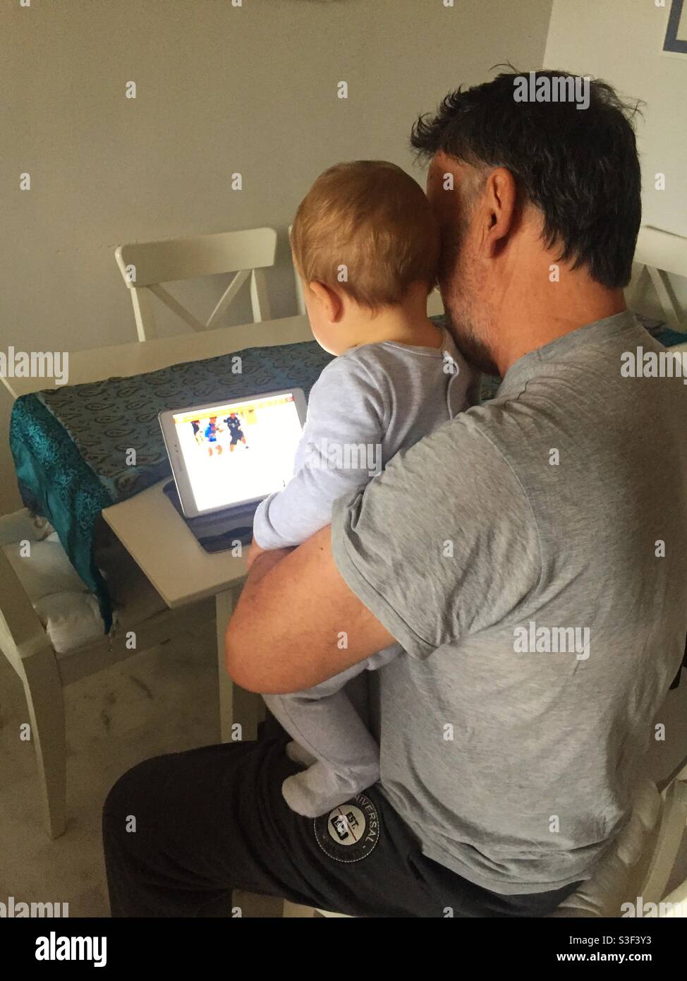 Mann und Baby beim Betrachen eines Tablet-Computers Stockfoto