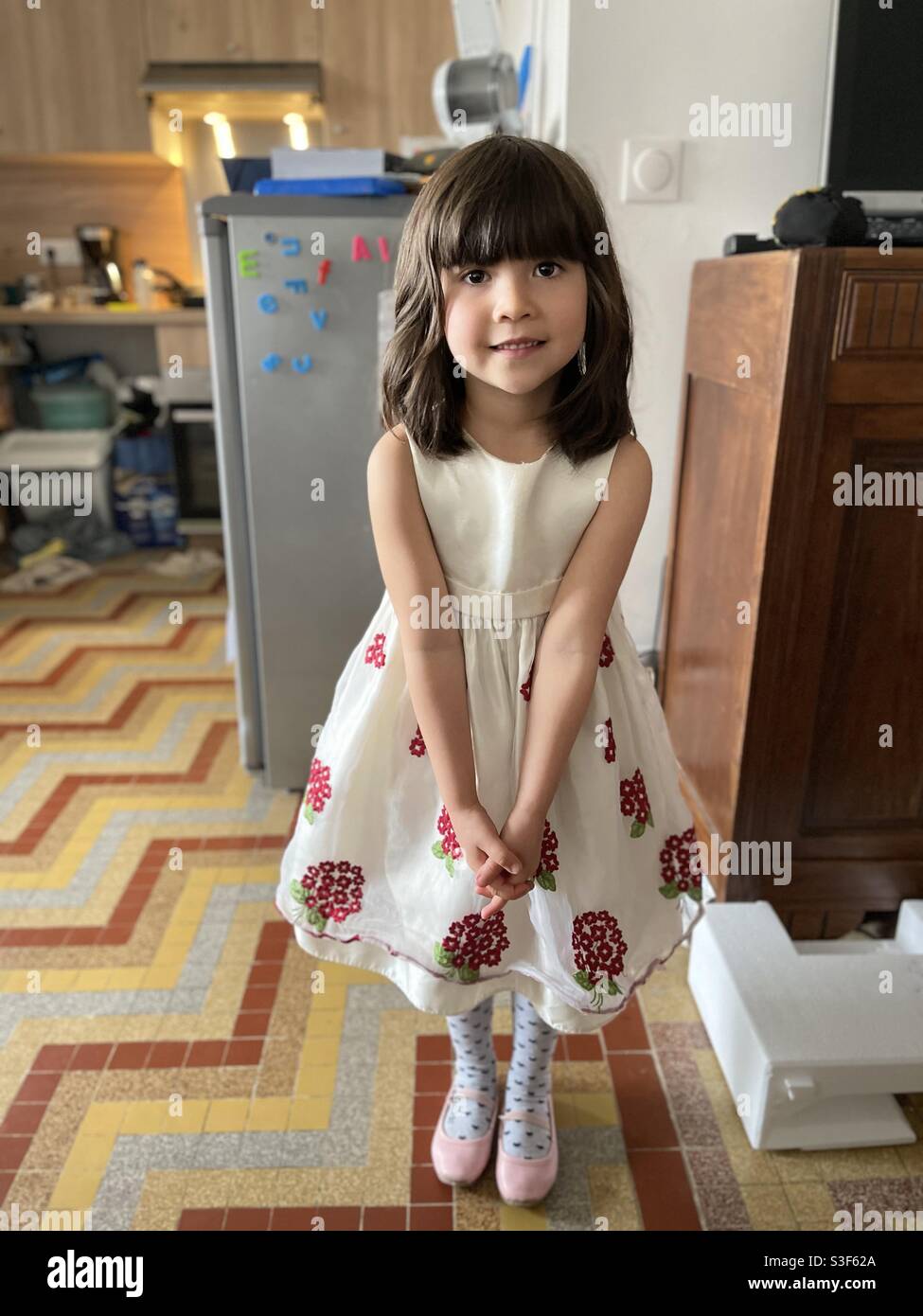 Schöne und nette gemischte asiatische kaukasische kleine Mädchen mit weiß  prinzessin Kleid mit roten Blumen halten die Hände und lächeln  Stockfotografie - Alamy