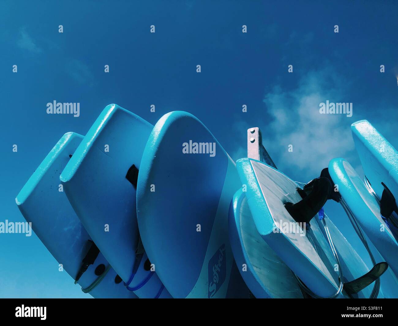 Blaue Surfbretter vor blauem Himmel an einer Surfschule in Cornwall Stockfoto
