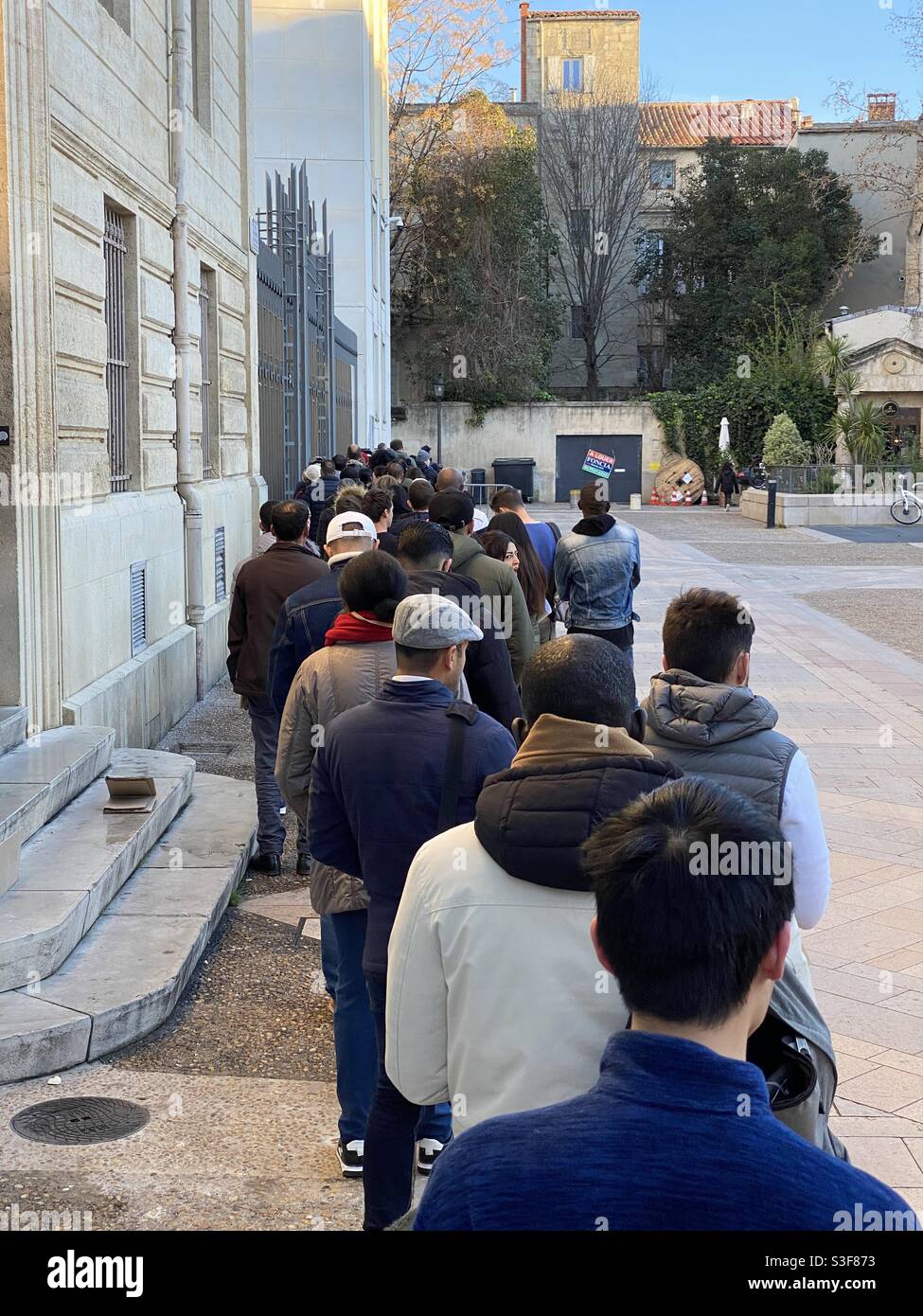 Im März 2019 stehen sich Menschen vor der Préfecture de l’Herault in Montpellier, Oskitanie, Südfrankreich, kurz vor der COVID-Pandemie an - Smartphone-aufgenommenes Stockfoto