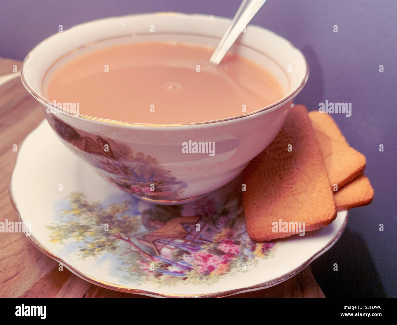 Tee und Bickies, Tasse Tee mit Milch in einem altmodischen Vintage feine porzellan-Tee-Tasse und Untertasse, traditionellen Stil, Teelöffel Stockfoto