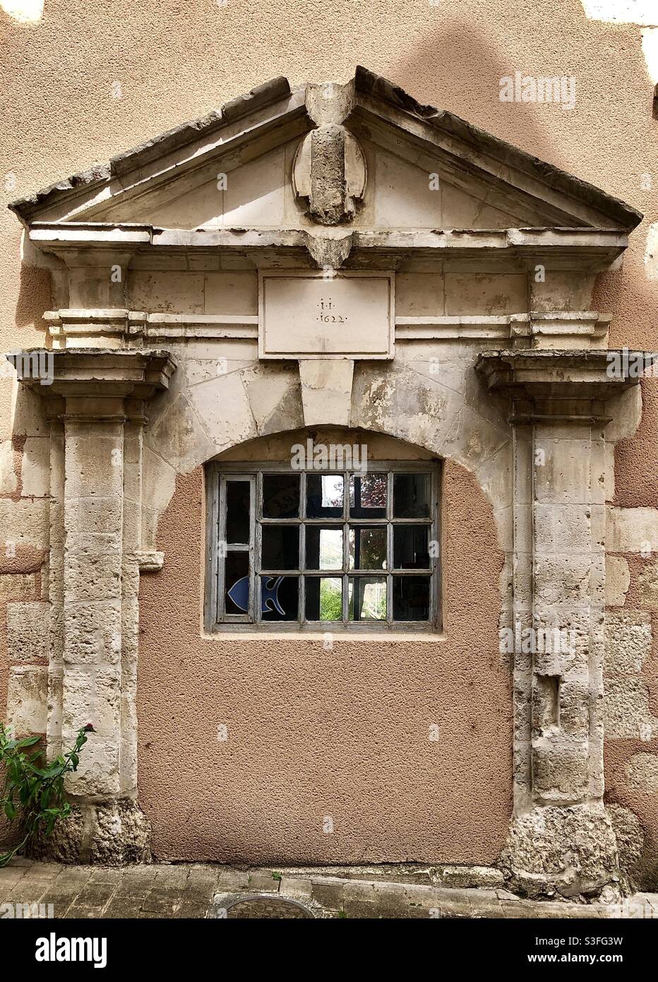 Kunstvoll verzierte Tür aus dem 17. Jahrhundert, die in der Neuzeit für ein Fenster blockiert wurde - Le Blanc, Indre (36), Frankreich. - Smartphone-aufgenommenes Stockfoto