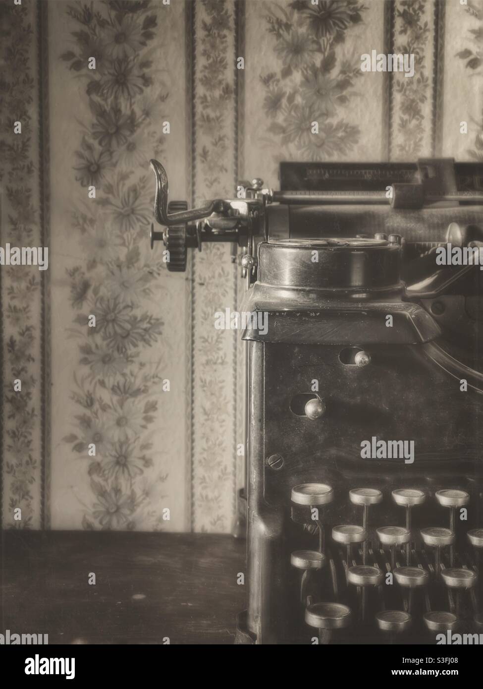 Sepiafarbtes Bild einer Vintage-Schreibmaschine vor Tapete in Vintage-Look - Smartphone-aufgenommenes Stockfoto