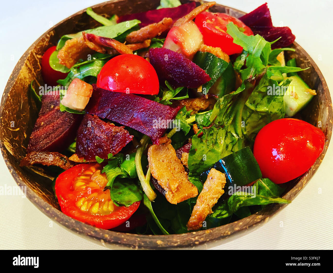 Salat mit veganen Kebab-Stücken in einer Kokosnussschale Stockfoto